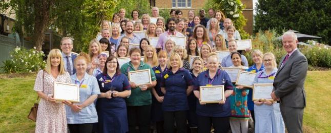 A group of staff holding certificates